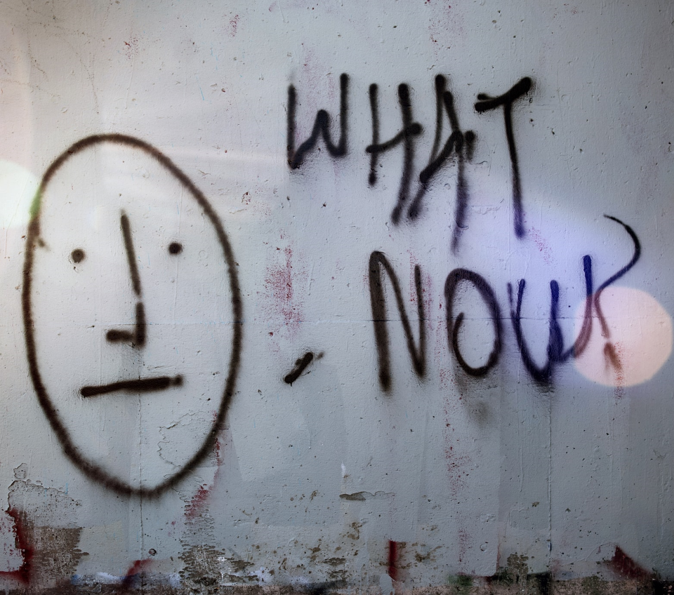 graphiti line drawing of a face with the caption 'what now?'